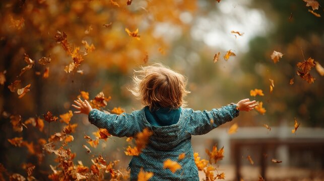 child playing autumn leaves with blured nature background