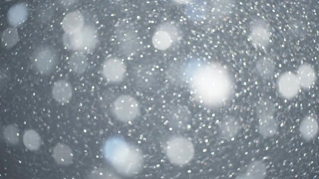 A close-up shot of falling snowflakes, with a blurred effect, creates a beautiful, cool, wintery scene