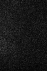 Fototapeta premium Scanned dark paper texture with fine vertical grain and soft fibrous detail. The deep black and charcoal tones create a minimal, elegant background ideal for modern design, overlays, packaging.