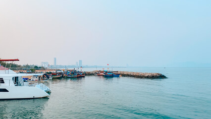 Fototapeta premium Scenic View of Harbor with Fishing Boats and City Skyline