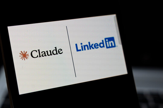 Warsaw, Poland - April 2, 2026: Display showing the logos of Claude and LinkedIn, symbolizing collaboration between AI and professional networking. Captured in a dark environment.