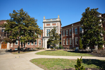 Fototapeta premium Wide view of a historic campus building with courtyard and trees