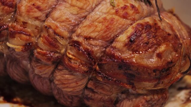 Close-up of juicy tasty grilled roast beef in baking dish. Roasted meat close-up.