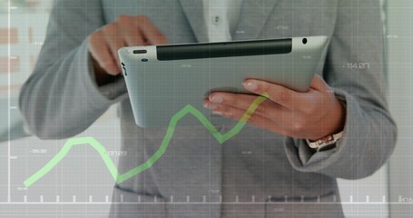 Holding businesswoman in light gray suit tapping silver tablet at office, with green chart overlay © vectorfusionart