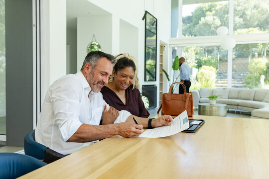 Vertical video: Signing couple in white shirt closing contract after form placed at home to seal it