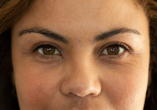 African woman looking directly toward camera in close-up studio portrait showing hoop earring