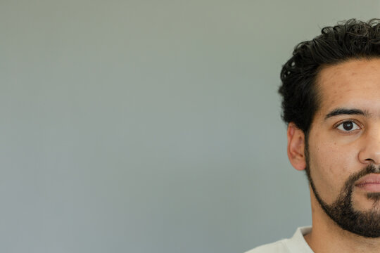 African American man posing in studio showing half face wearing crewneck shirt, copy space