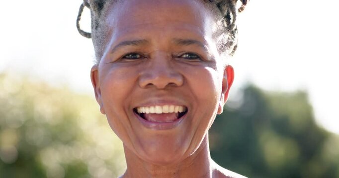 Senior African woman looped hair smiling, shifting to laughter, nodding, reacting to camera in park
