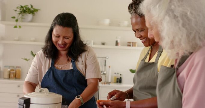 Diverse female friends starting to cook with aprons at kitchen counter peeling loading steamer