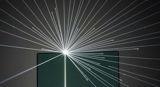 Laser beams radiating from a bright light source creating a starburst effect.