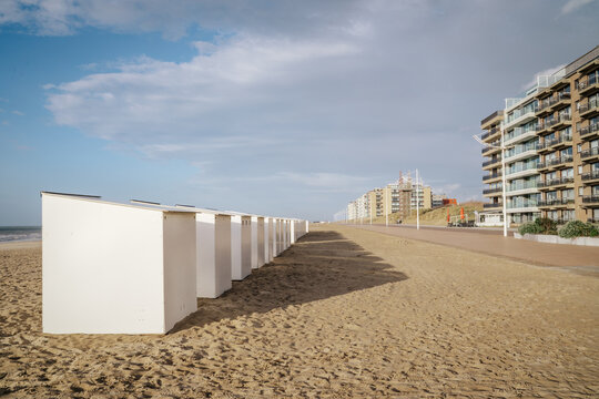Row of white beach huts on the shore of Koksijde, Belgium