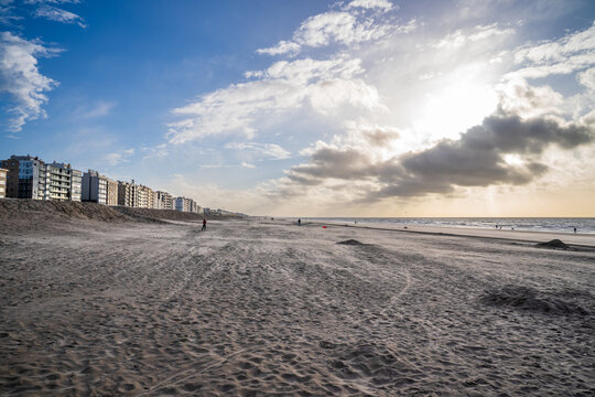 Wide beach of Koksijde with waterfront buildings at sunset, Belgium