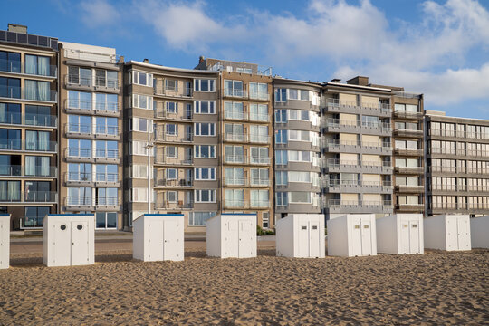 White beach huts and apartment buildings on the seafront of Koksijde, Belgium