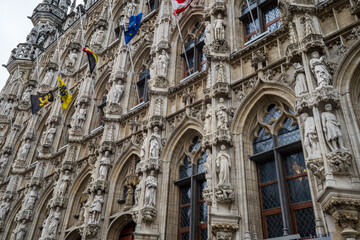 Obraz premium Detail of Leuven Gothic Town Hall Facade with Statues and Flags