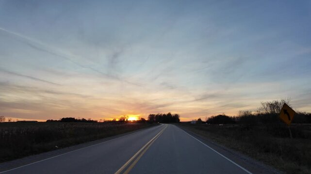Driving Along a Country Road With Curves During Sunset Hours