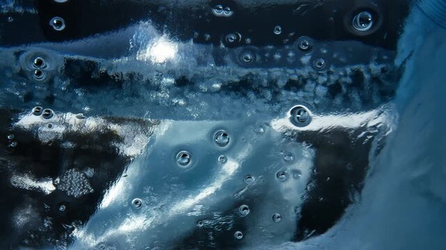 Ultra HD Extreme Macro Shot of Tiny Air Bubbles Trapped Inside Crystal Clear Blue Glacial Ice with Glistening Light Reflections 4K Video
