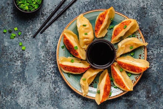Dumplings served on a plate with green onions