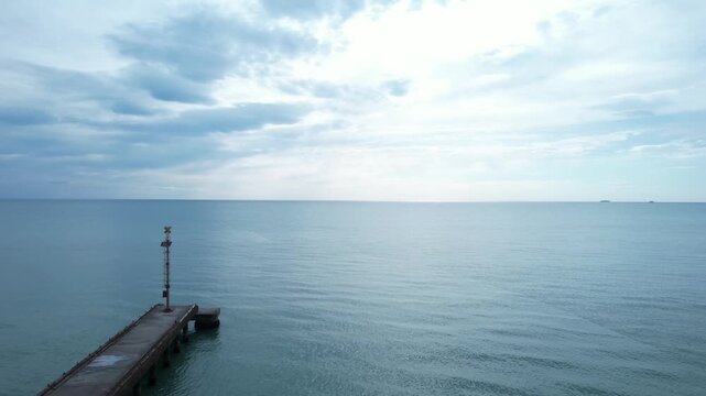 Aerial drone shot of Cinquale pier stretching into calm sea.
