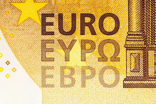 The inscription EURO on a fifty Euro banknote. Fragment of an orange Euro banknote
