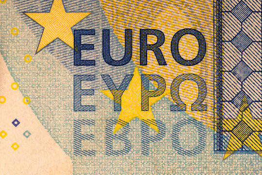 The inscription EURO on a twenty Euro banknote. Fragment of a yellow and blue Euro banknote