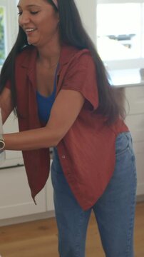 Vertical video: Leaning home cook rust top pulling towel from low oven placing in green bin cooling