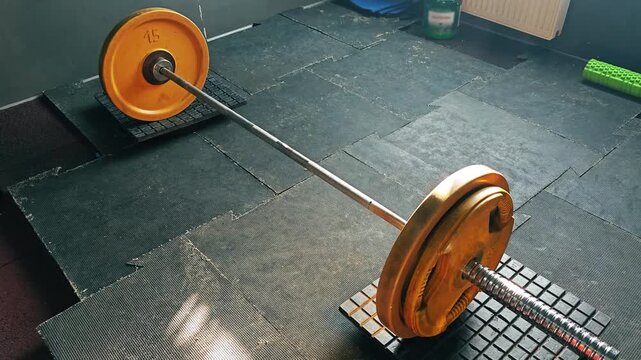 Barbell with small weight plates on gym floor