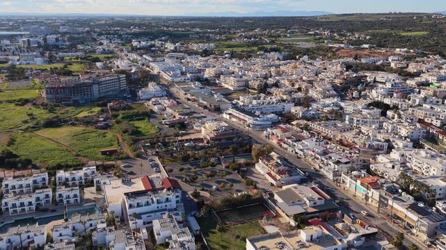 Aerial drone view of urban area, showing residential buildings, roads, and Mediterranean town layout