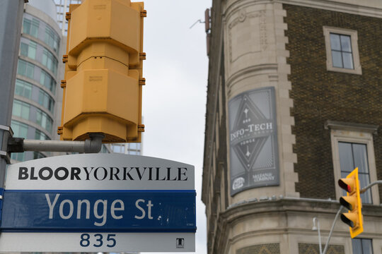 City of Toronto road sign at Yonge St in the Bloor Yorkville neighborhood with defocused view of 888 Yonge St (The Masonic Temple), Toronto