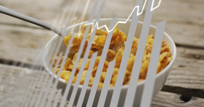 White zigzag appearing, metal spoon lifting and scooping corn flakes over bowl to showcase cereal