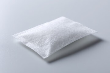 Naklejka premium Close-up of a single white sugar packet on a pristine white background