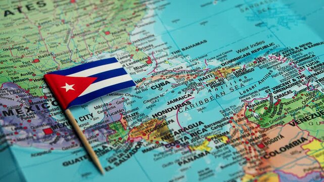 Hand adjusts Cuba flag on detailed island nations map