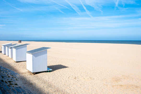 Panorama of beach huts, blue sky, sun and sand dunes, Ostend, North Sea coast, Belgium.
