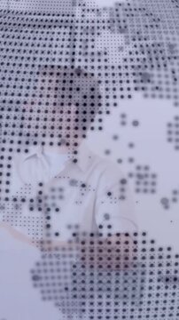Vertical video: Dotted overlay shifting revealing seated man at business desk turning head thinking