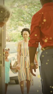 Hosts holding handles opening door, mom daughter entering home while golden bokeh surrounding them