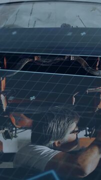 Vertical video: Auto tech fixing pipe via rear glass, lift raising, blue overlay guiding repair