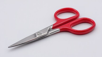 Obraz premium Red-handled scissors with shiny metal blades, lying flat on a white surface.