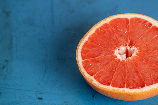 Grapefruit cut in half on colorful surface 