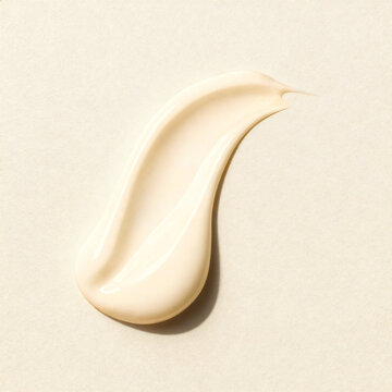 Cosmetic creamy smear on beige background, skin care product texture closeup.
