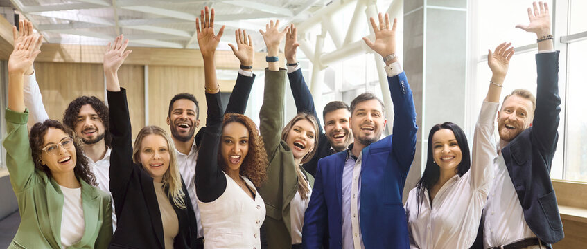 Team business professionals and colleagues cheer celebration success. Diverse coworkers raise hands in a bright office, showing unity and confidence after a win. Success and teamwork unity concept.