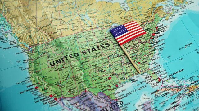 Hand adjusts USA flag on detailed continental map