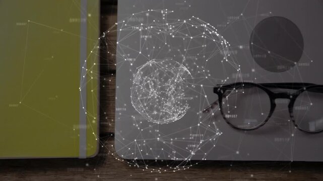 Laptop and eyeglasses resting on wooden desk, showing yellow notebook beneath digital web overlay