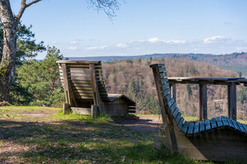 Obraz premium Wooden Lounge Chairs at a Scenic Forest Viewpoint Overlooking Rolling Hills and Valley Landscape