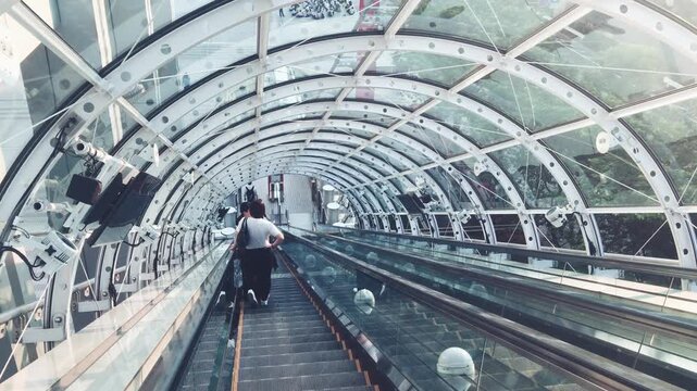 TOKYO, JAPAN - MAY 2016: Tourists along the escalator in Odaiba