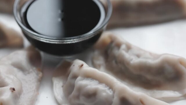 Close-Up of Gyoza with Soy Sauce Served on White Plate