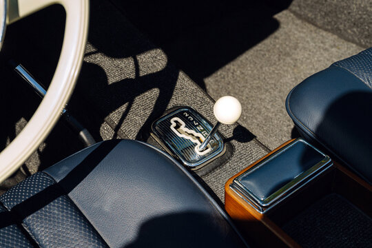 Classic Car Interior Closeup With White Ball Gearshift, Blue Leather Seats and Wood Console Trim