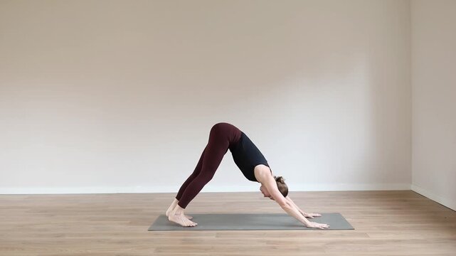 A young woman practicing yoga in a bright modern studio, focusing on balance, breathing, and mindfulness.