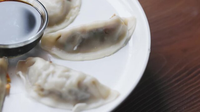 Close-Up of Gyoza with Soy Sauce Served on White Plate