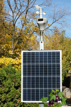 Automatic weather station with solar panel and antenna on metal pole. Meteorological equipment. Solar powered weather station for remote data collection. Environmental monitoring technology