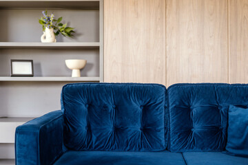 Modern living room with blue velvet sofa and minimalist wooden storage