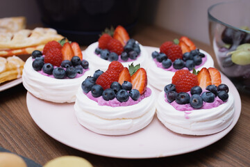 Mini bezy z kremem i świeżymi owocami na talerzu © Tadeusz